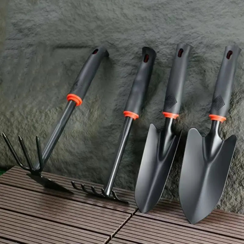 A Set of Four Outdoor Gardening Tools Including a Small Shovel for Planting Flowers, a Five-Pronged Rake, a Double-Headed Rake, Metal Tool Kit